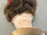 a doll that has a hair bun on it ' s head