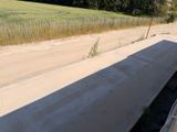 un camion qui roule sur la route à côté d'un champ