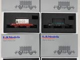 six boîtes contenant des wagons de train miniature, exposées sur une surface blanche