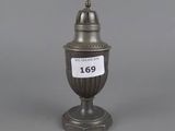 a silver vase with a label on it sitting on top of a table