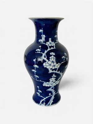 un vase bleu orné de fleurs blanches sur fond blanc