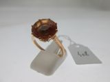 Gros plan sur une bague ornée d'une pierre brune