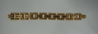 a close up of a gold bracelet on a white surface