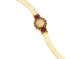 a close up of a gold wrist watch with a red face