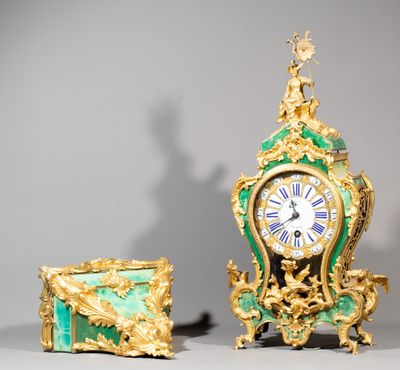 a gold and green clock sitting next to a green box