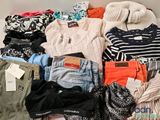 a pile of clothes that is sitting on a bed