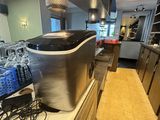 une photo d'une cuisine avec de nombreuses bouteilles d'eau posées sur le plan de travail