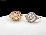two gold and silver rings with diamonds on a white surface