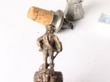 a small figurine of a man with a cork stopper