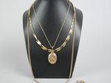 un collier en or avec une pièce et une chaîne, posé sur un mannequin