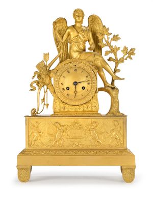 une horloge en or surmontée d'un ange
