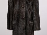 un manteau de fourrure noir sur un stand de mannequin