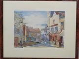 framed watercolor painting of a street scene with buildings in the background