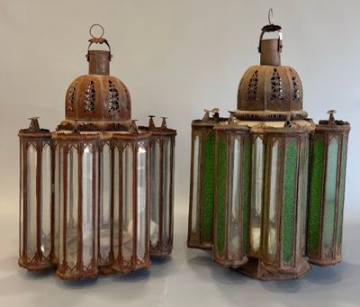 une paire de lanternes en verre vert posées sur une surface blanche