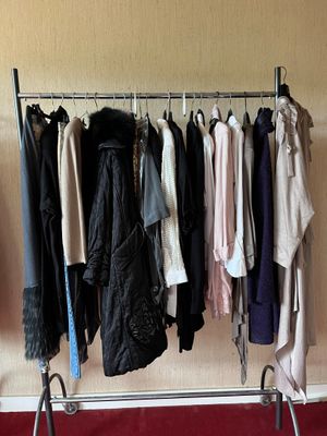 a lot of clothes hanging on a rack in a room