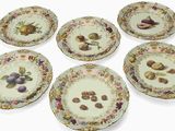 six assiettes ornées de motifs de fruits variés sur un fond blanc