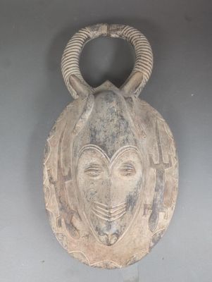 un masque accroché au mur, orné de cornes