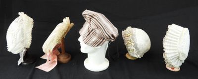 Plusieurs chapeaux sont alignés sur une surface noire