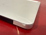 a close up of a white laptop on a red surface
