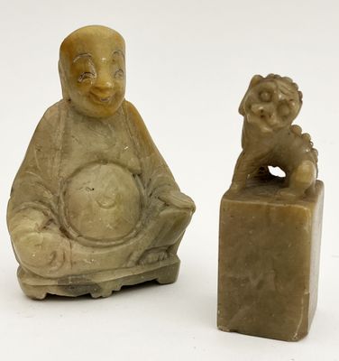 une petite statue représentant un homme assis à côté d'une petite statue représentant un chien