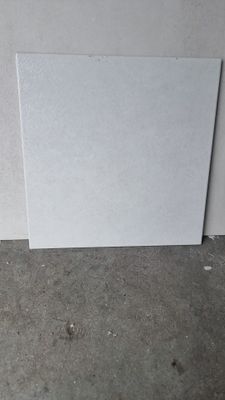 un morceau de papier blanc posé par terre près d'un mur