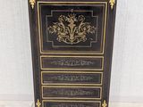 a black and gold chest of drawers with ornate designs