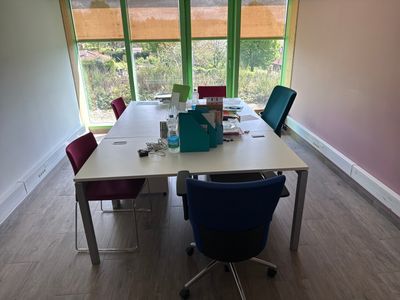 a long table with chairs and a laptop on it in a room