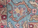 an antique persian rug with a blue background and a red border