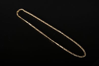 un collier en or avec une chaîne sur fond noir