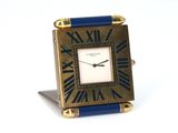a small clock with roman numerals on it