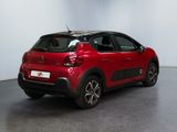 the rear of a red car parked in a large room