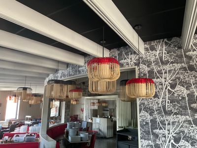 une photo d'un restaurant avec beaucoup de tables et de chaises
