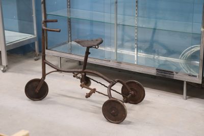 un vieux tricycle exposé dans une vitrine
