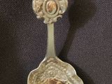 a silver spoon with a bird on top of it