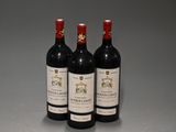 trois bouteilles de vin rouge posées sur une table