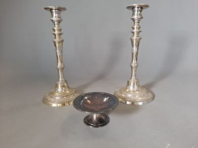 two silver candlesticks sitting next to each other on a table