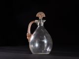 an old glass jug with a handle on a black surface