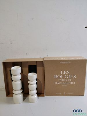 three white candles sitting in a box next to each other