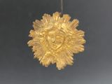 a gold ornament hanging from a chain