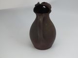 a small brown vase sitting on a white surface