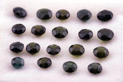 un ensemble de pierres précieuses noires et vertes sur un fond blanc