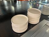 il y a beaucoup d'assiettes blanches sur le plan de travail de la cuisine