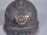 un vieux casque de pompier posé sur une surface blanche
