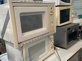 trois micro-ondes empilés les uns sur les autres sur une table