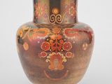 un vase avec un motif floral sur une surface blanche
