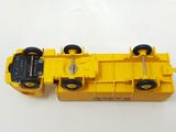 a yellow toy truck with black wheels on a white surface