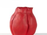 un vase rouge posé sur une table