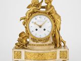 une horloge en or sur laquelle figurent une femme et un enfant