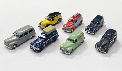 plusieurs petites voitures sont alignées sur une surface blanche