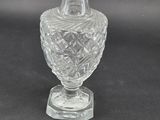an image of a clear glass vase with a stopper next to it